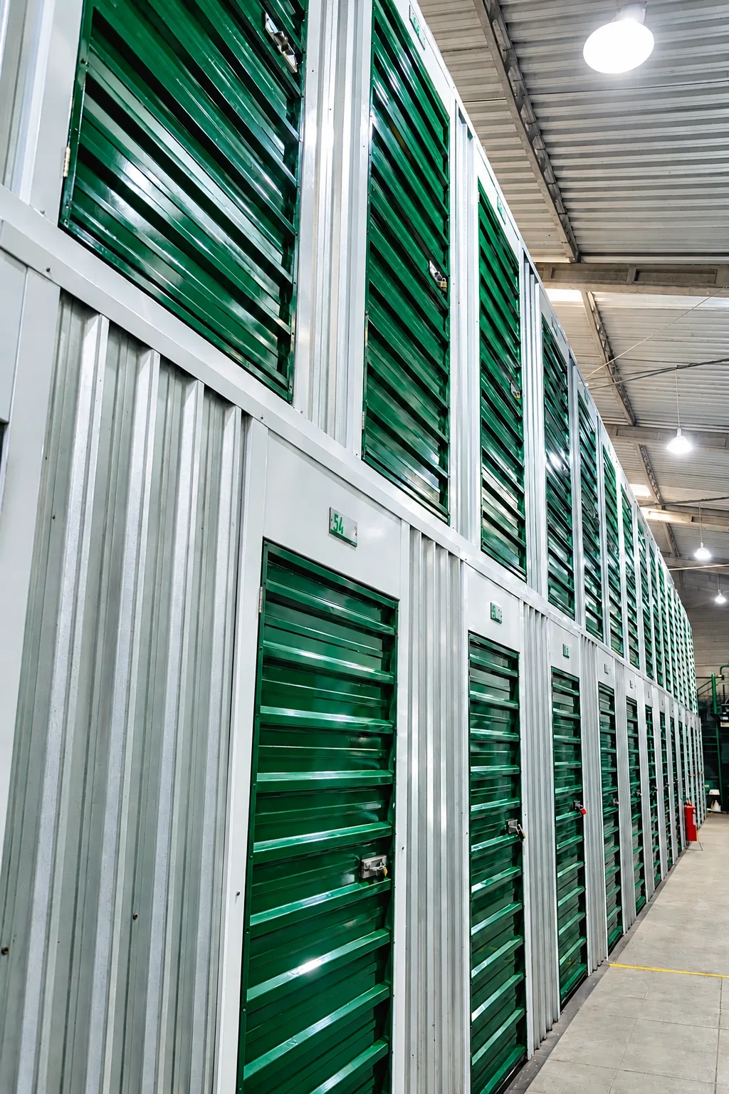 Corredor com boxes de portas verdes em dois níveis na Alogue